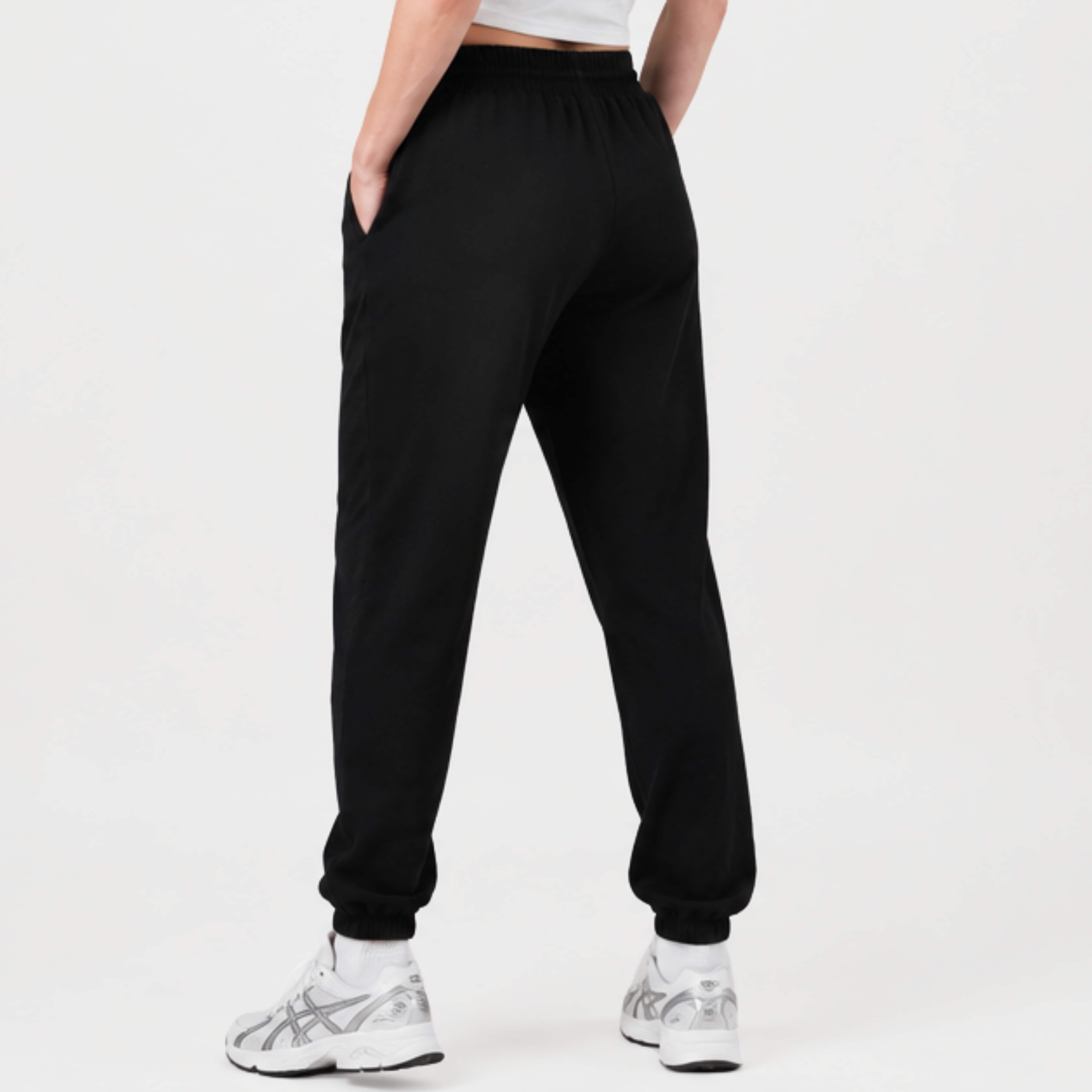 Person wearing a black  Kovered leakproof trackies on a white background