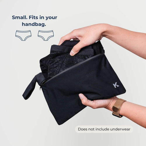 Woman placing leakproof underwear into the Kovered small dual-pocket DryBag — discreet waterproof wet bag for spare pairs on the go