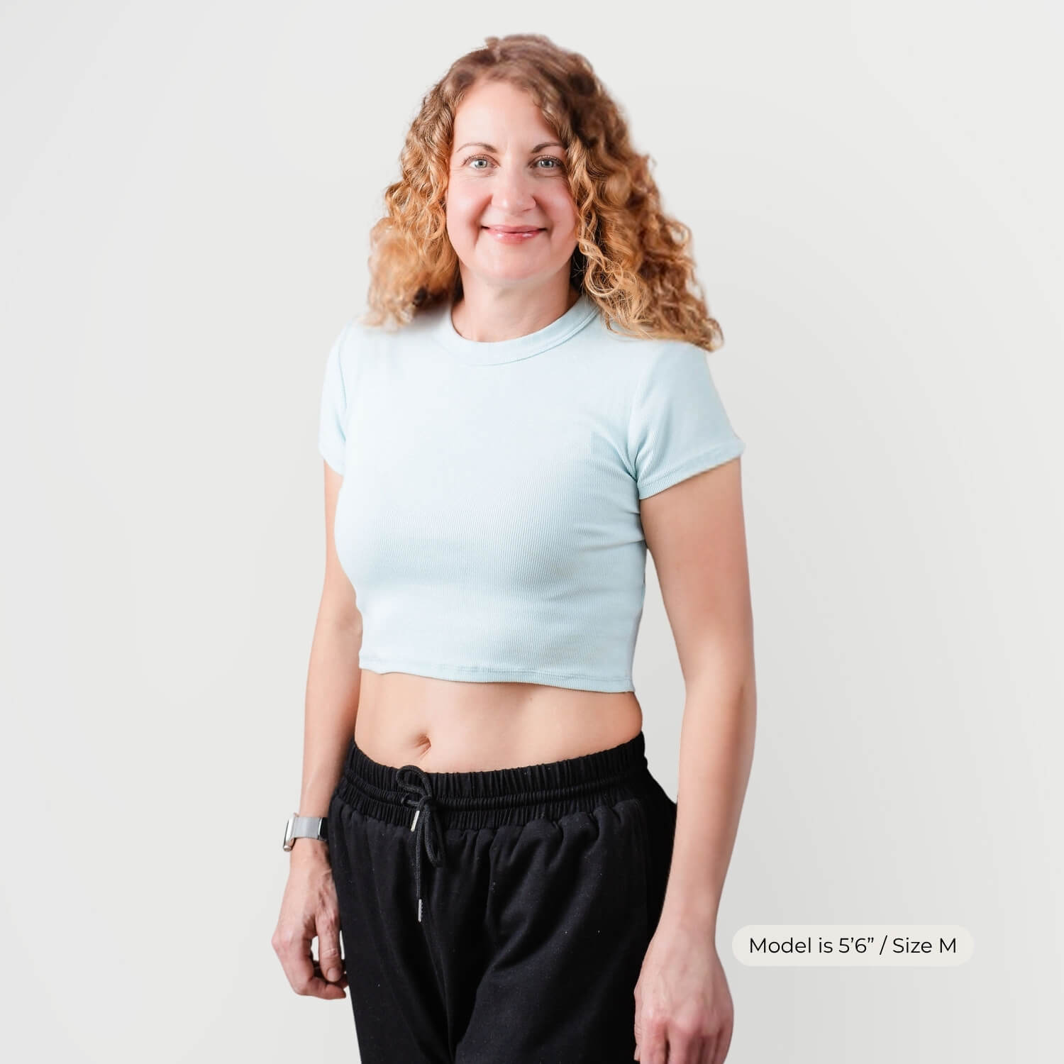 Woman wearing Kovered leakproof trackpants in black — unisex design, looks like normal trackpants, Size M